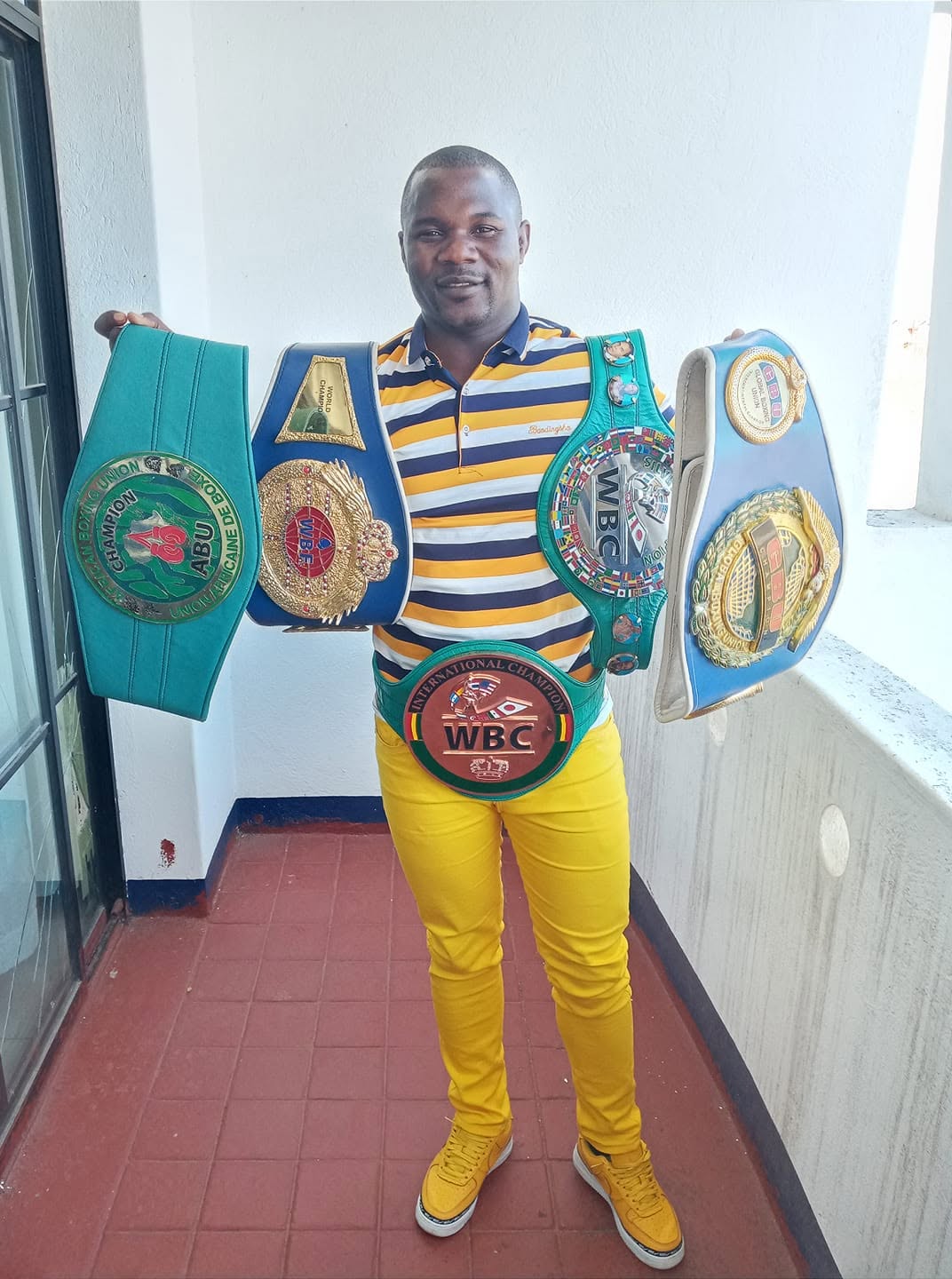 Charles Manyuchi wearing every championship belt at once